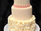Pink and white wedding cake with flourishes